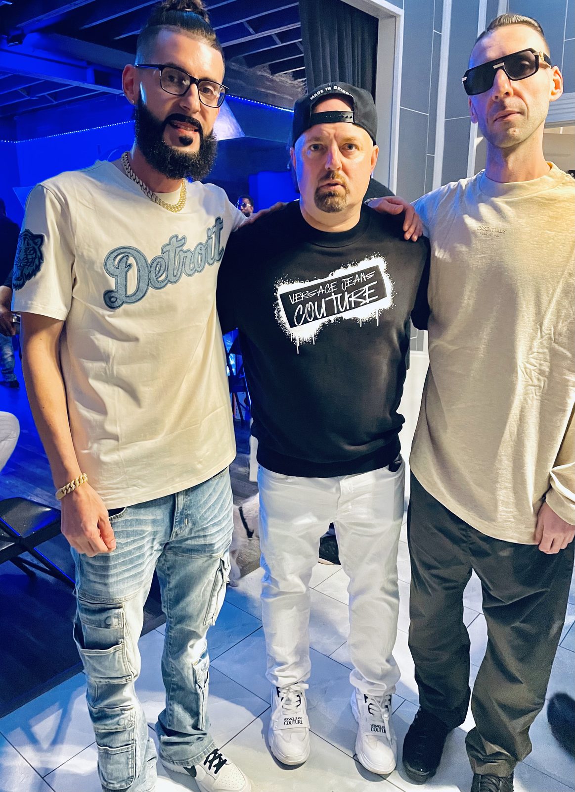 KING T and LUSS with a friend in Detroit shirts in a blue-lit room