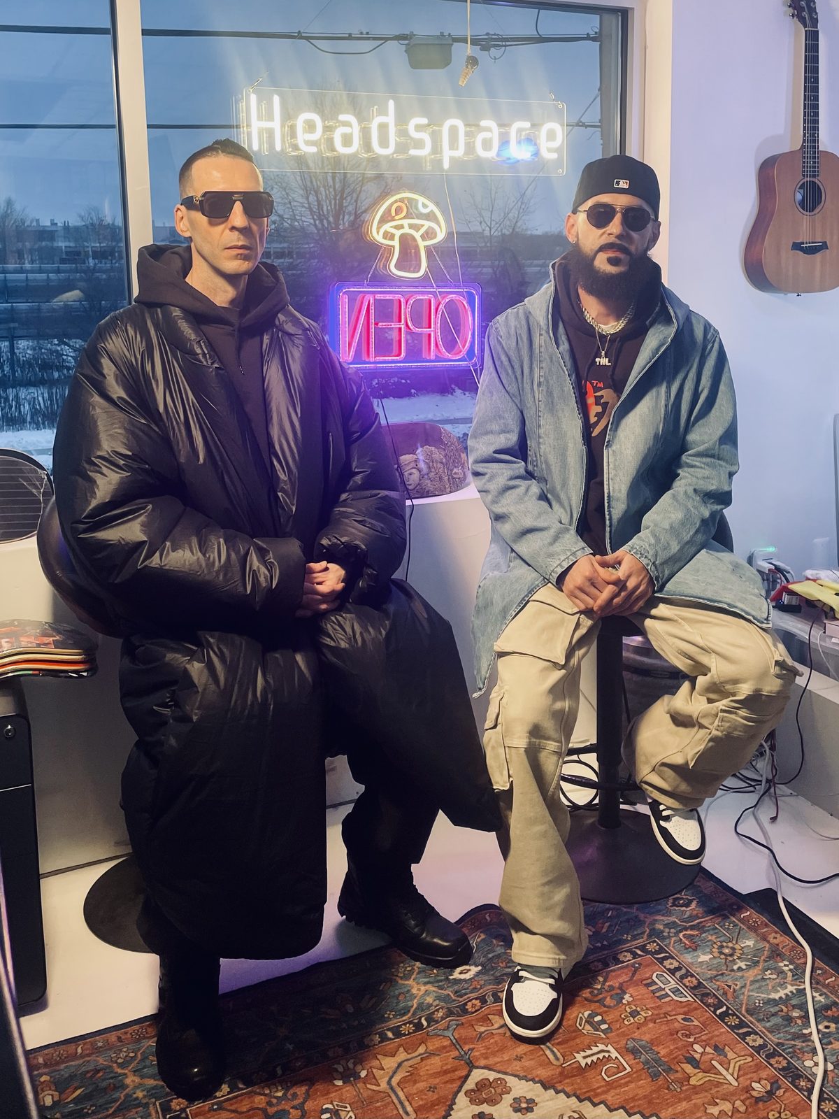 KING T and LUSS at the Headspace studio in front of a neon OPEN sign
