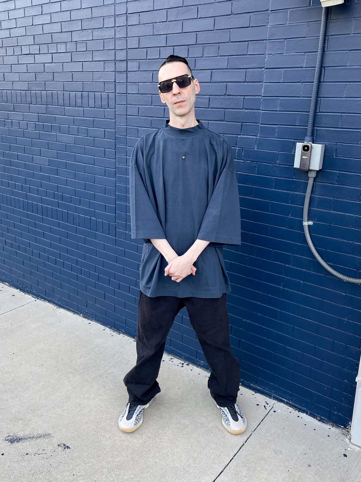 KING T against a blue brick wall