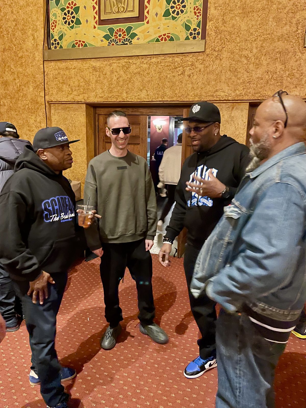 KING T talking with friends at an ornate venue