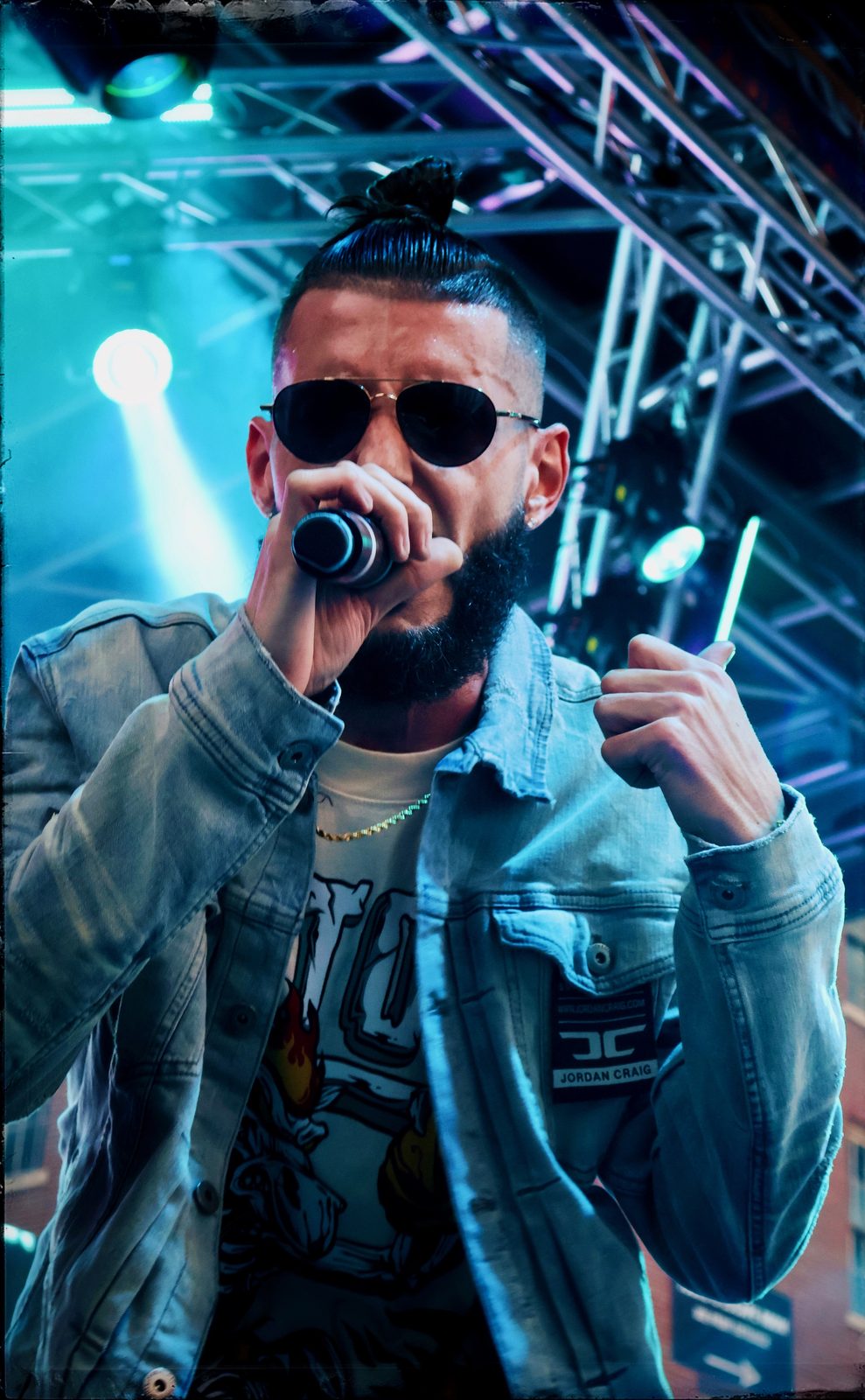 Performing with a mic on stage in a denim jacket