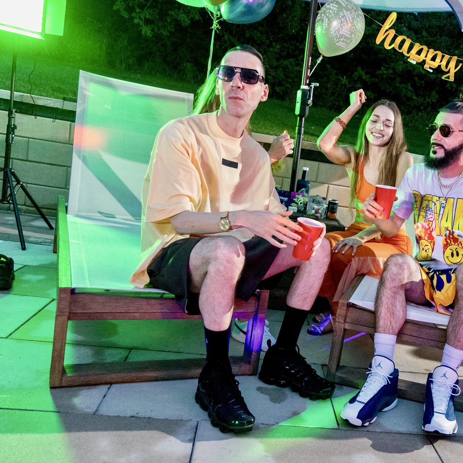KING T at a pool party music video shoot in green light