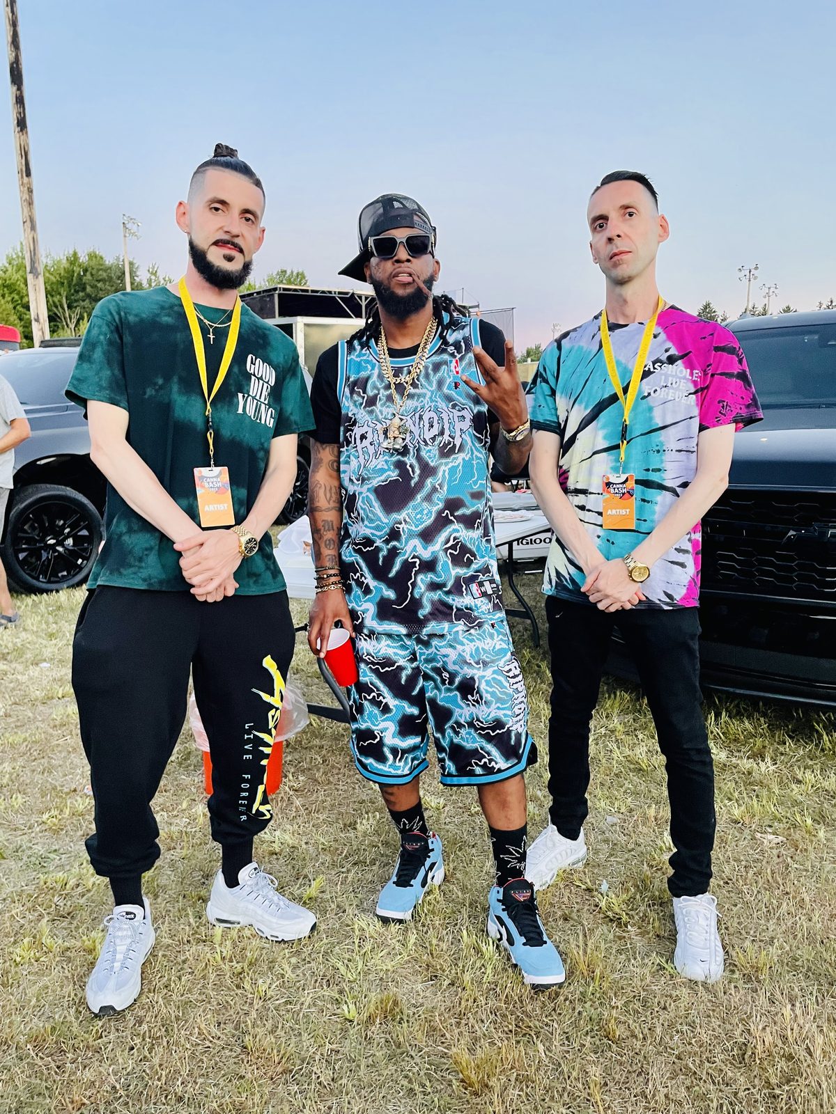 KING T and LUSS with a fellow artist on the grass at a festival